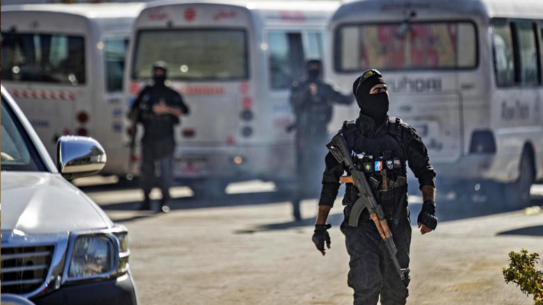 Members of Kurdish security forces deploy around buses carrying women and children from families of Islamic State fighters, July 25, 2022. (Photo: Delil Souleiman/AFP)