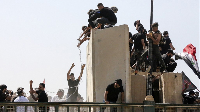 Supporters of the Iraqi cleric Moqtada Sadr use chains to bring down concrete barriers along the Al-Jumhuriya (Republic) bridge that leads to the capital Baghdad's high-security Green Zone, July 30, 2022. (Photo: Sabah Arar/AFP)