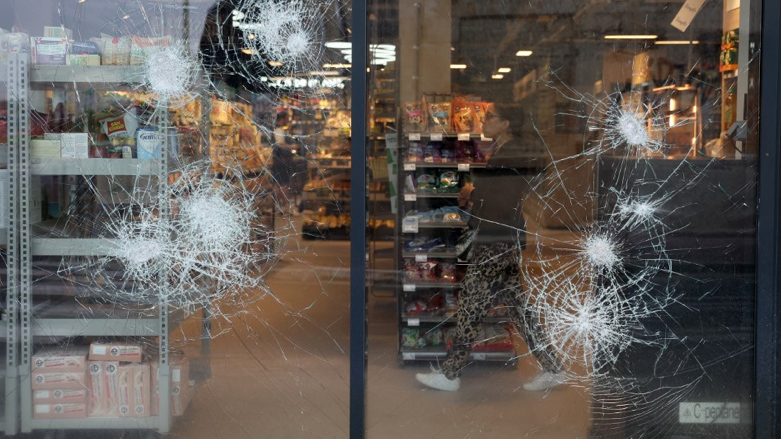 An employee is seen behind the broken windows of a supermarket following a fourth consecutive night of rioting in France (Photo: ROMAIN PERROCHEAU/AFP)