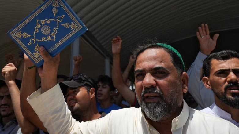 Supporters of Iraq's Sadrist movement Sadr hold up the Quran during a protest following Friday prayers in Nassiriyah on June 30, 2023 (Photo: Asaad Niazi/AFP)