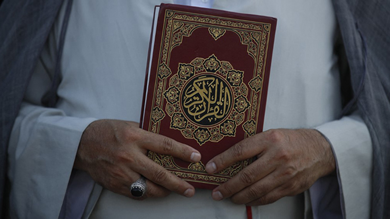 A cleric holds a Quran outside the Swedish embassy in Baghdad  for a second day of protests against a Koran burning, June 30, 2023. (Photo: Ahmad Al Rubaye/AFP)