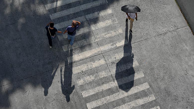 A man uses an umbrella to shield him from the afternoon sun in Manila, Philippines, July 6, 2023. (Photo: AP/Aaron Favila)