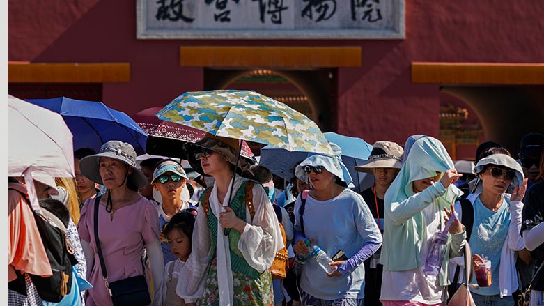 Visitors wear sun hats and carry umbrellas as they leave the Forbidden City on a hot day in Beijing, June 29, 2023. (Photo: AP/Andy Wong)
