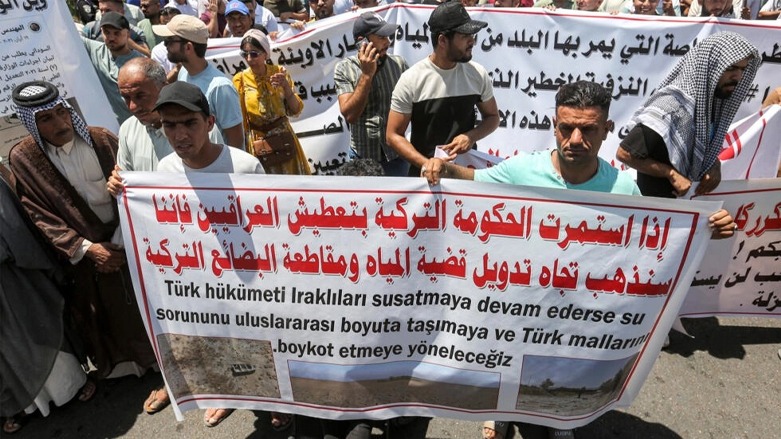 متظاهرون عراقيون يحملون لافتة تحمل تركيا مسؤولية نقص المياه خلال احتجاج في بغداد في 18 تموز/يوليو 2023 © مرتجى لطيف / اف ب