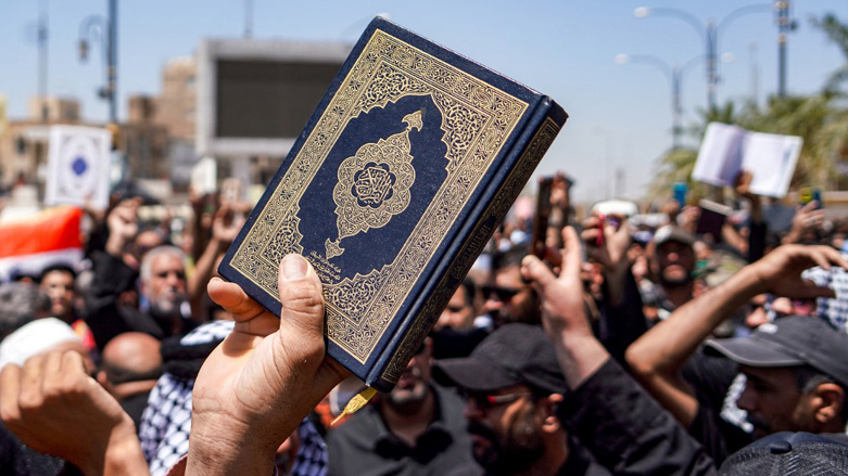 A demonstrator holds a copy of the Quran, Islam's holy book, during a rally in Iraq's central shrine city of Kufa east of nearby Najaf after the weekly Friday prayers denouncing the burning of the Quran in Sweden, July 21, 2023. (Qassem al-