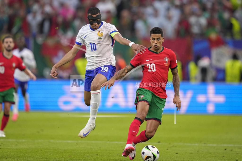 Kylian Mbappe of France challenges for the ball with Portugal's Joao Cancelo during a quarterfinal match between Portugal and France. (Photo: AP) 