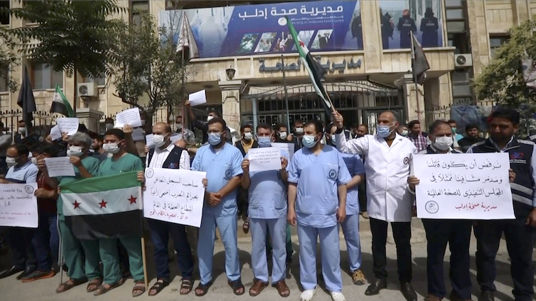 In this image taken from video, dozens of medical workers protest a decision to grant Syrian President Bashar Assad’s government a seat on the World Health Organization executive board, May 31, 2021, in Idlib, Syria. (Photo: AP)