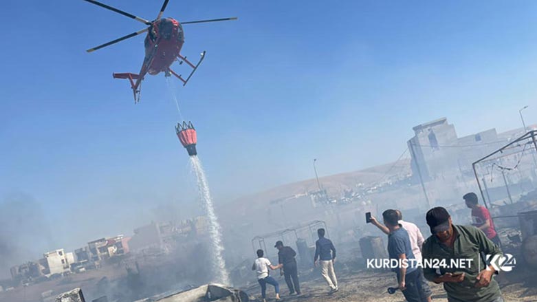 Firefighters working to extinguish a fire that broke out in the Sharya refugee camp in Duhok province, which houses displaced Yezidis from Sinjar, on June 4, 2021. (Photo: Star Ahmed / Kurdistan 24).