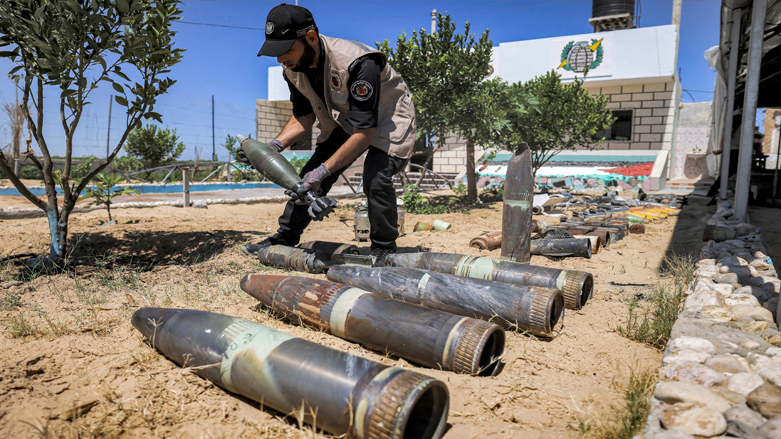 An explosives expert of Hamas lays out unexploded projectiles from the aftermath of the May 2021 conflict with Israel, at a local police precinct in Khan Yunis in the southern Gaza Strip, June 5, 2021. (Photo: Mahnud Hams / AFP)