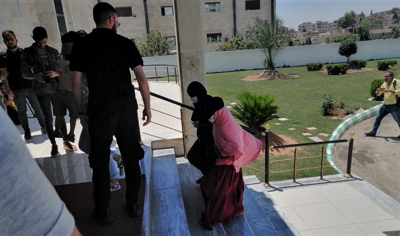 Members of the media take photos of a Dutch woman with alleged links to ISIS and her children as they arrive arrive at an office of the local Kurdish-led administration in Qamishlo, Syria, June 5, 2021. (Photo: Kurdistan 24/Hisham Arafat)