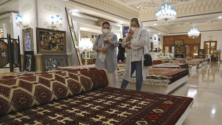 Customers look at rugs at a hand crafts store at Iran Mall shopping center in Tehran, June 9, 2021. Iranians point to the economy as the major issue facing it ahead of its June 18 presidential election. (Photo: Vahid Salemi/AP)