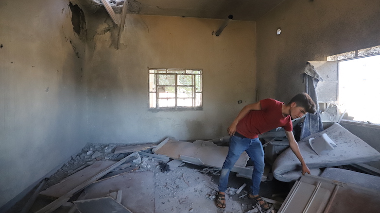 A youth searches through debris in a house hit by Syrian government bombardment in the village of al-Mantaf in the Jabal al-Zawiya region in Syria’s rebel-held Idlib province on June 22, 2021. (Photo: Abdulaziz Ketaz/AFP)