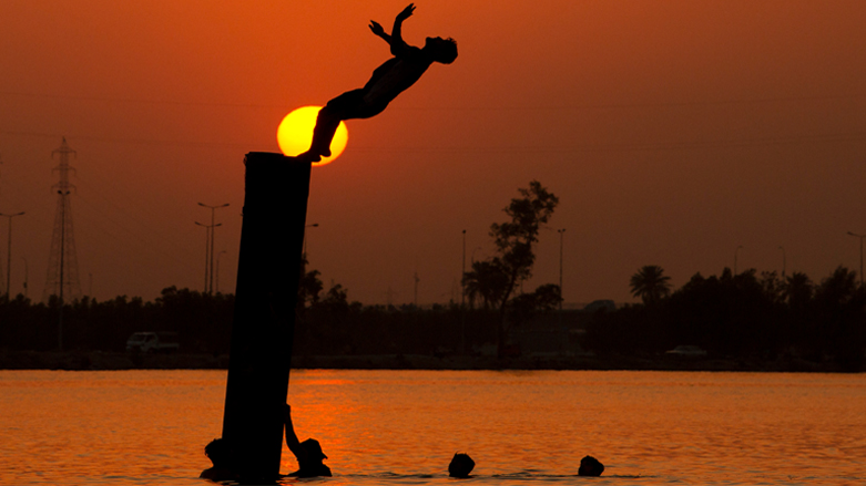 Iraqi youth swim in the Shatt Al-Arab river by the port of Maqil amid a heatwave in the southern Iraqi city of Basra, June 29, 2021. (Photo: Hussein Faleh/AFP)