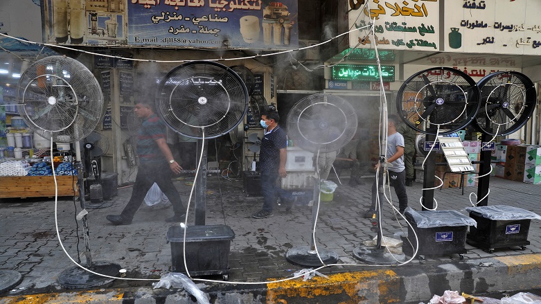 Electric fans spraying a mixture of water and air cool down pedestrians amid a scorching heatwave in Baghdad, June 30, 2021. (Photo: AFP/Ahmad Al-Rubaye)