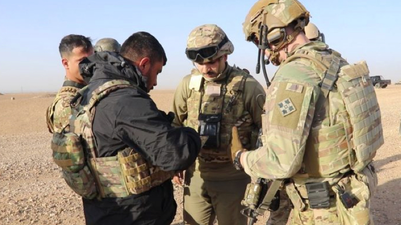 SDF fighter and US-led coalition troops (Photo: SDF Press)