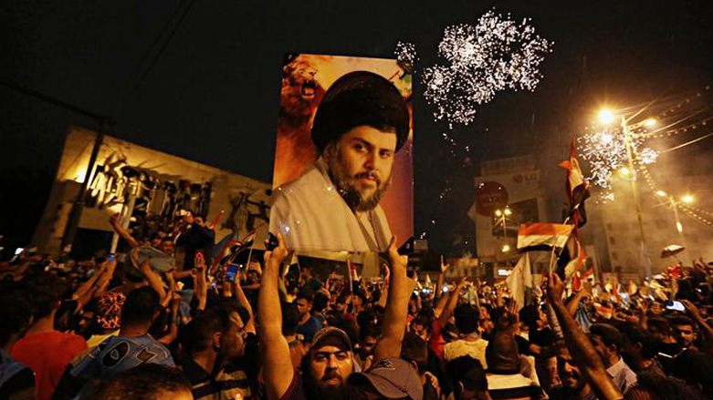 Supporters hold a banner with the picture of Muqtada al-Sadr in a spontaneous rally after preliminary results of the Iraqi 2018 elections were announced showing Muqtada al-Sadr has become the unexpected frontrunner. (Photo: H. Mizban/AP)