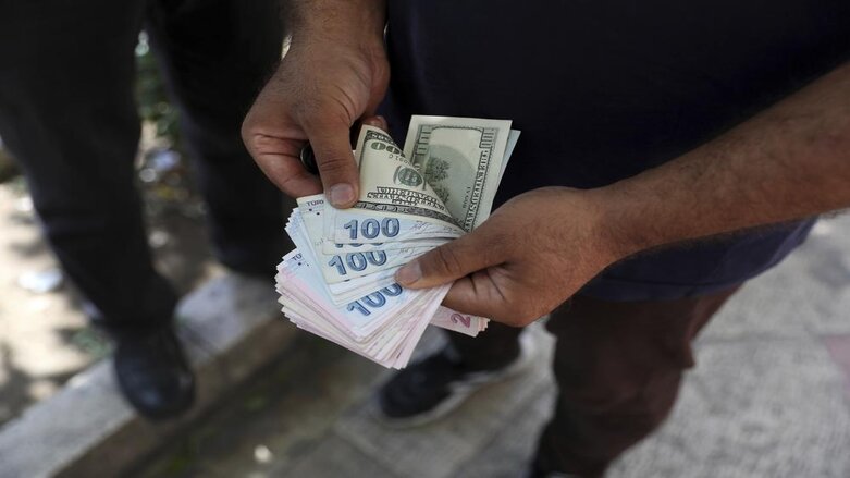 A street money exchanger poses for a photo without showing his face as he counts foreign banknotes in Ferdowsi street, Tehran's go-to venue for foreign currency exchange, Iran, Sunday, June 12, 2022 (Photo: Vahid Salemi/AP)