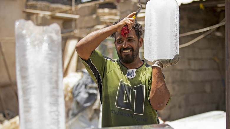 A man carries a block of ice at his stall in Iraq's southern city of Basra, June 11, 2022. (Photo: Hussein Faleh/AFP)