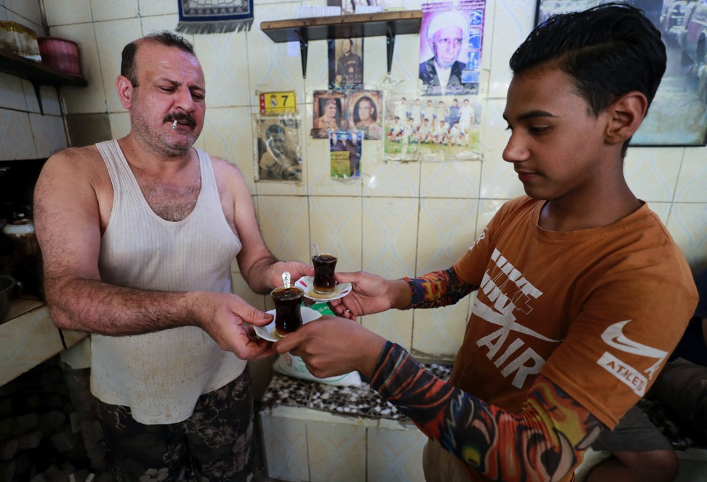 An Iraqi tea vendor prepares an order for customers in the capital Baghdad, June 11, 2022. (Photo: Ahmad Al-Rubaye/AFP)
