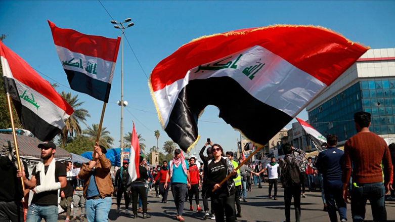 Students and other demonstrators hold national flags during a protest to condemn a pro-Iran militia attack on Najaf protesters, in Tahrir Square, Baghdad, Iraq, Feb. 6, 2020. (Photo: Khalid Mohammed/AP)
