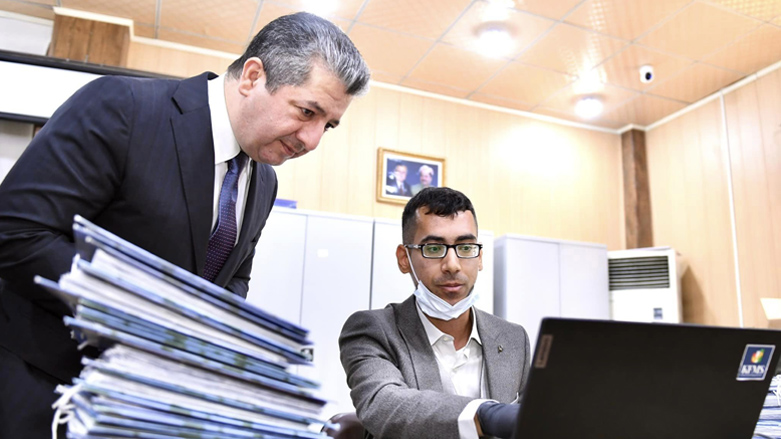 Kurdistan Region Prime Minister Masrour Barzani (left) looking on as an employee undertakes digitization of archives at KRG Directorate of Social Security in Erbil, Jan 14, 2023. (Photo: KRG)
