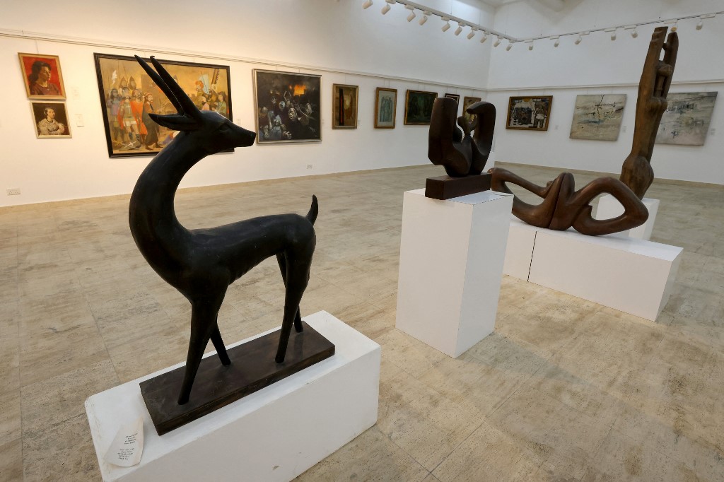 A sculpture of a gazelle by Iraq's Khaled Izzat with a painting behind it by Jawad Salim (2nd L) as well as other artwork by renowned Iraqi painters at the Museum of Modern Art in Baghdad, May 28, 2023. (Photo: Ahmad Al-Rubaye/AFP)