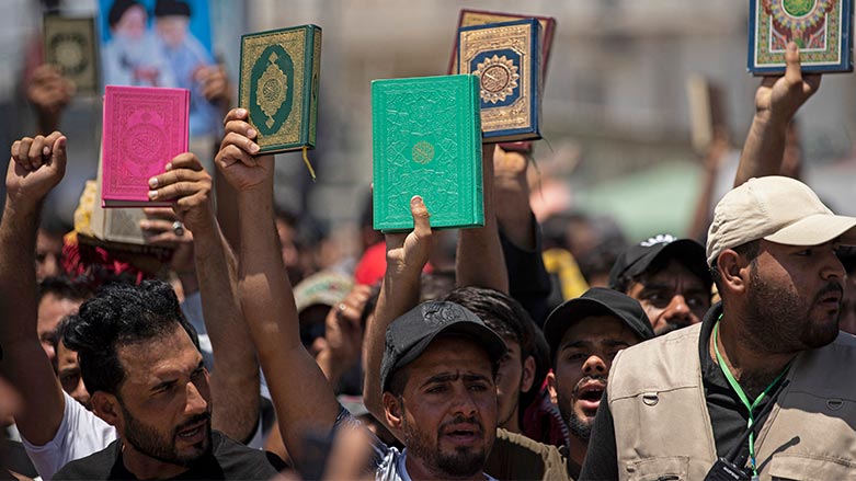Supporters of Iraq's Sadrist movement hold up the Koran during a protest in Basra on June 30, 2023. (Photo: Hussein Faleh / AFP)