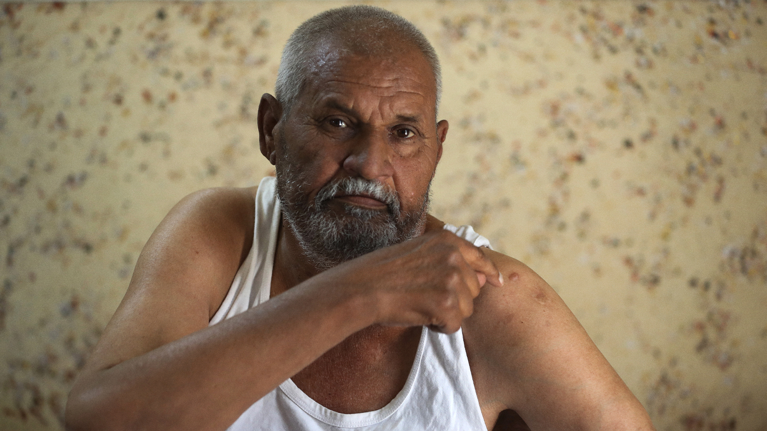 Saad Abbas, 59-years-old, who was injured by a random gunshot in his home in a village in the Yusufiya area near Baghdad on May 20, 2024, shows off his injury as he sits in his home during a government campaign to register the weapons in possession of citizens. (Photo: AFP)