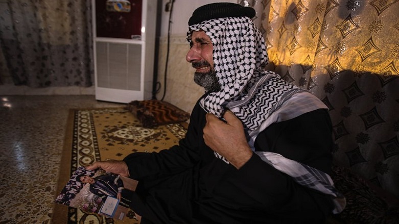 Jasb Hattab Aboud, father of the kidnapped protester Ali Jasb, cries as he holds his son's picture in his home in the town of Amara,Iraq. Aboud was shot to death Wednesday, March 10, 2021. (Photo: AP)