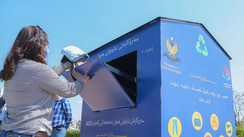 A participant puts in trousers and shirts into a drop box installed to collect clothes and footwear for poor families in the Kurdistan Region's capital Erbil, March 29, 2021. (Photo: KRG Ministry of Municipalities and Tourism)