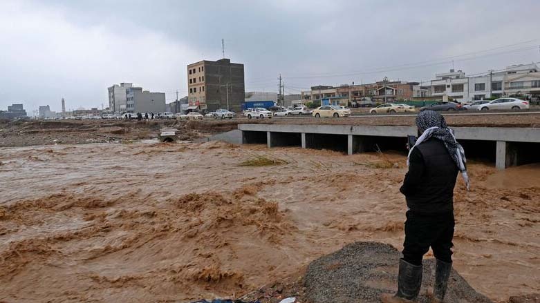 A resident takes a video of the water levels of a river on the outskirts of Erbil, on Dec. 17, 2021, after flash floods caused by torrential rains left eight people dead. (Photo: AFP)