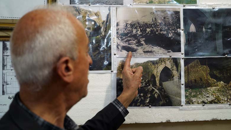 Joseph Elias Yalda, director of the Heritage Museum of al-Qosh, points to old photographs depicting the Prophet Nahum synagogue, Feb. 3, 2022. (Photo: Ismael Adnan/AFP)