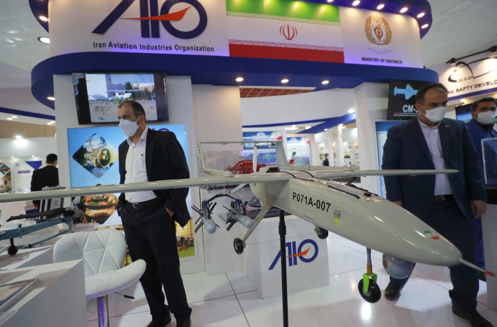 Iranian delegates stand near models of military weapons during the 10th edition of the Baghdad security, defence and military industry fair, March 2, 2022. (Photo: Ahmad al-Rubaye/AFP)
