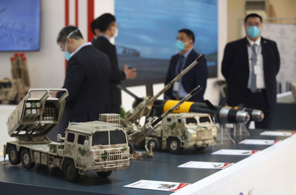Representatives from Chinese arms and military manufacturers stand near models of weapons at their stand during the 10th edition of the Baghdad security, defence and military industry fair, March 2, 2022. (Photo: Ahmad al-Rubaye/AFP)