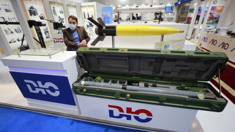 Iranian delegates stand near models of military weapons in the Iranian military wing during the 10th edition of the Baghdad security, defence and military industry fair, March 2, 2022. (Photo: Ahmad al-Rubaye/AFP)