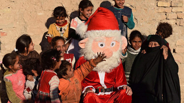 Impoverished Iraqi children pose for a photo with a man dressed as Santa Claus distributing gifts in the southern shrine city of Najaf. (Photo: Haidar Hamdani/AFP)