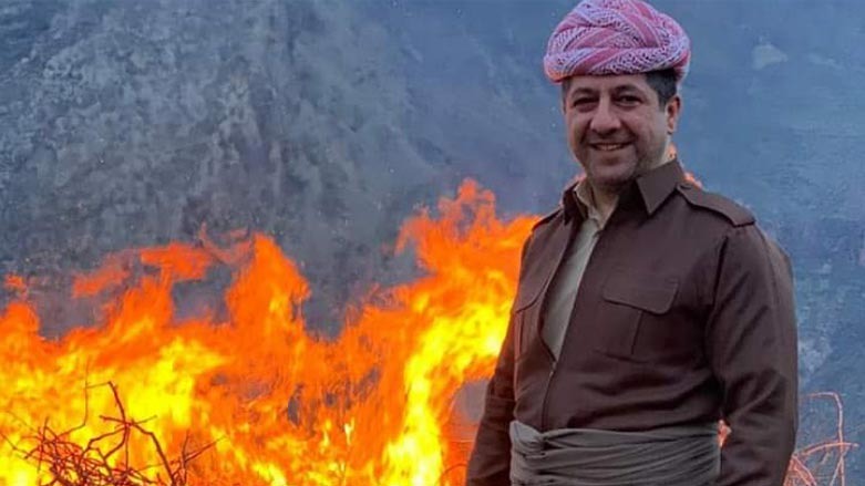Kurdistan Region Prime Minister Masrour Barzani poses for a photo in front of a bonfire on March 21, 2021. (Photo: Handout)
