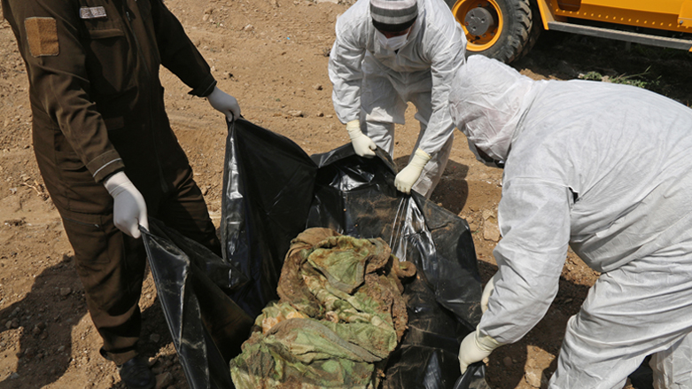 Iraqi forensic personnel examine human remains unearthed from a mass grave recently discovered in the northern Iraqi city of Mosul, March 20, 2022. (Photo: Zaid Al-Obeidi/AFP)
