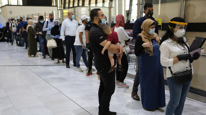 Passengers wearing protective masks wait in line to check in for their flights at the departure hall of Baghdad International Airport, July 23, 2020. (Photo: Ahmad al-Rubaye/AFP)
