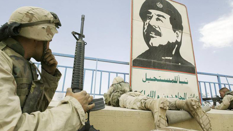 US marines take position near a portrait of then Iraqi leader Saddam Hussein in Baghdad, during the Second Gulf War in 2003. (Photo: AFP)