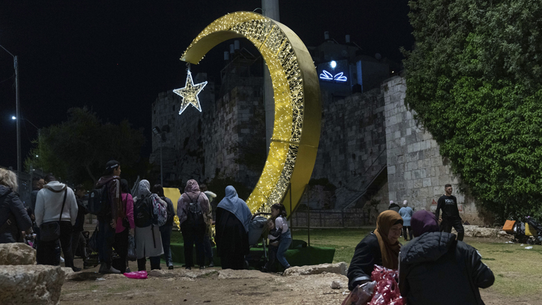 فلسطینی‌ها در آغاز ماه مبارک رمضان، درست خارج از شهر قدیمی اورشلیم، کنار چراغ‌های تزئینی دور هم جمع می‌شوند عکس – آسوشیتد پرس