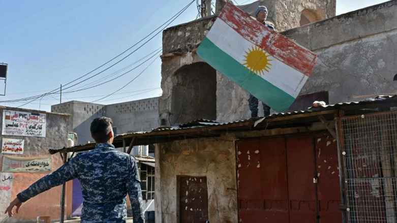 Iraqi fighters tear down a sign painted with the colors of the Kurdish flag in Kirkuk, Oct. 20, 2017. (Photo: Marwan Ibrahim/AFP)