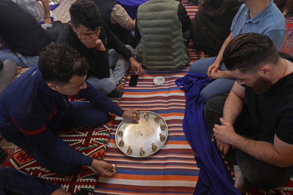 A number of customers play Siniyah at Nabaz Chawshin's cafe in Erbil, March 26, 2023. (Photo: Safin Hamed/AFP)