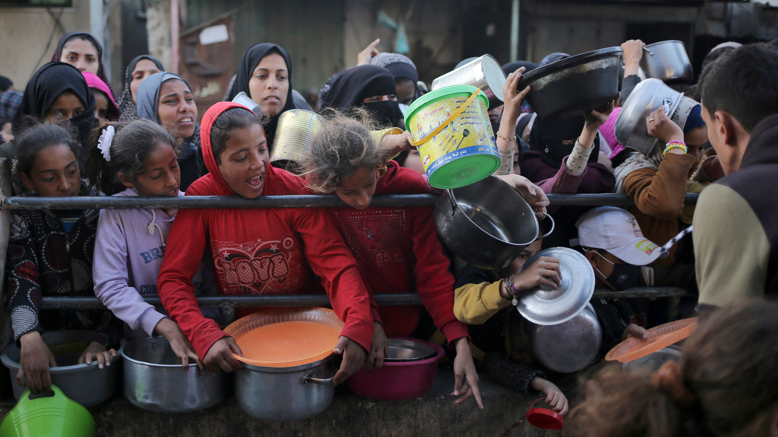 بەشێک لە منداڵانی غەززە هەوڵی بەدەستهێنانی خواردن دەدەن (وێنە: AFP)