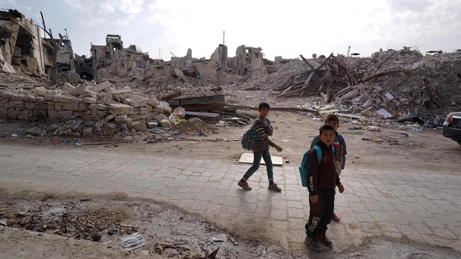 أطفال يشقون طريقهم إلى المنزل من المدرسة عبر شوارع حلب المدمرة في نوفمبر 2017