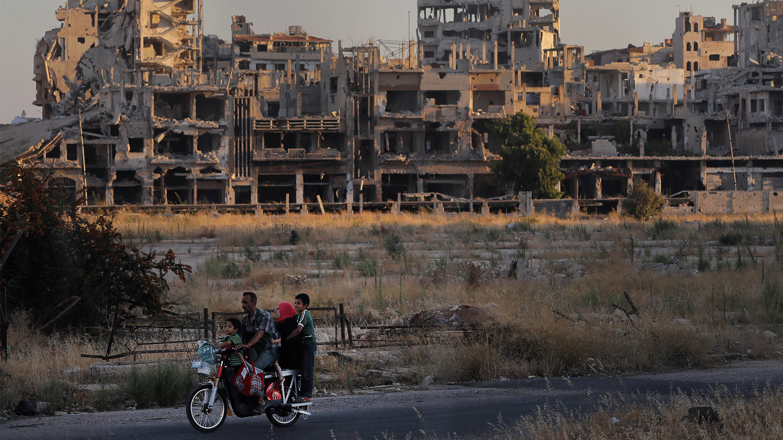 People ride their motorcycle by damaged buildings in the old town of Homs, Syria, Aug. 15, 2018. (Photo: AP)