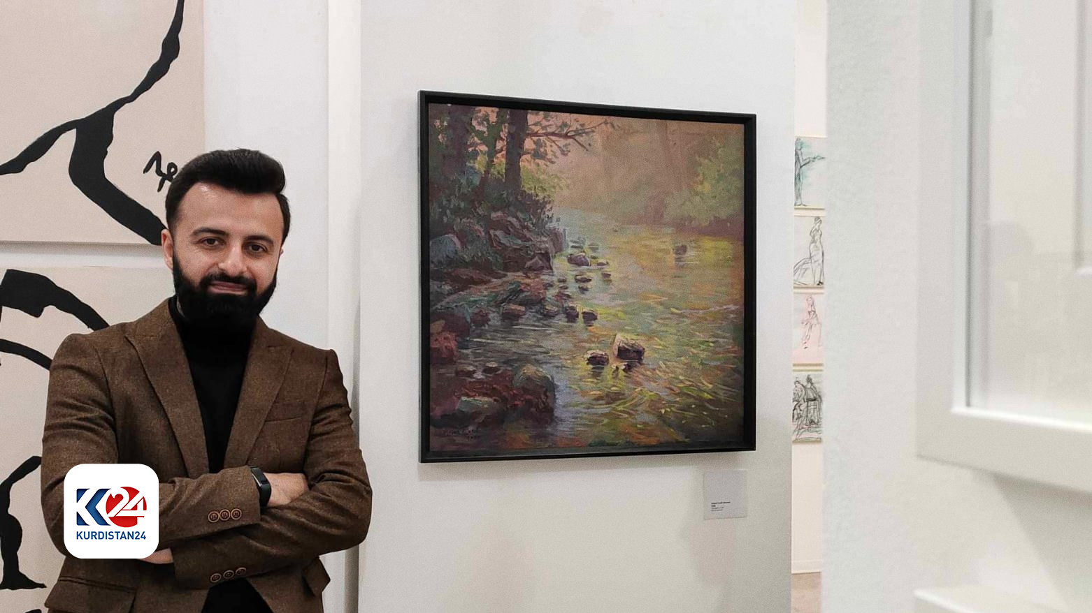 Kurdish painter Arian Lateef posing for a picture next to one of his paintings. (Photo: Submitted to Kurdistan24)