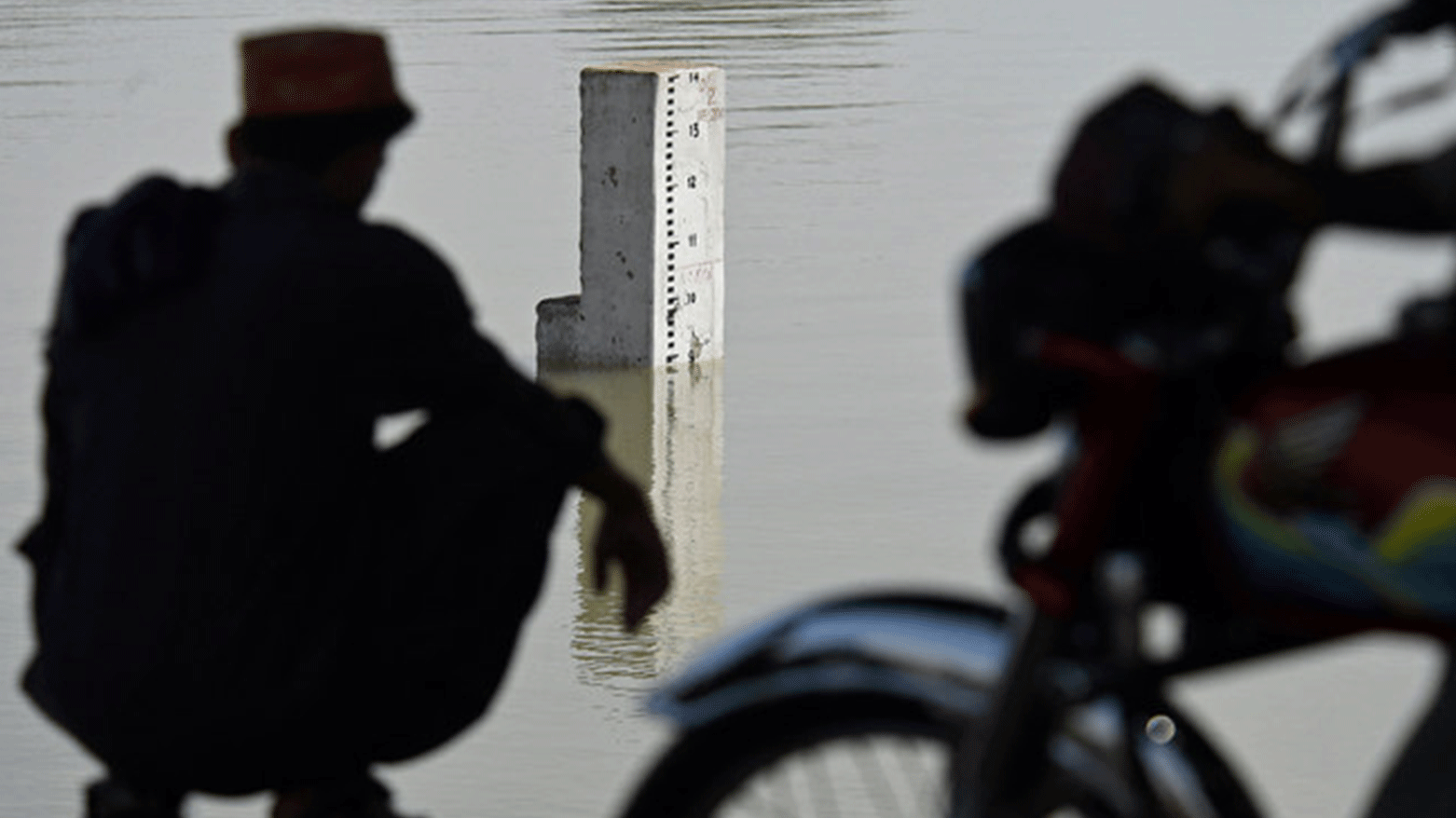 A resident from the nearby neighbourhood looks on the water level scale of river Indus in flood hit Sukkur of Sindh province. (Photo: AFP)