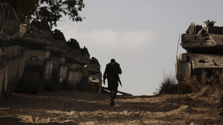 An Israeli soldier walks at a staging ground near the border with the Gaza Strip, in southern Israel, May 20, 2021. (Photo: Maya Alleruzzo/AP)