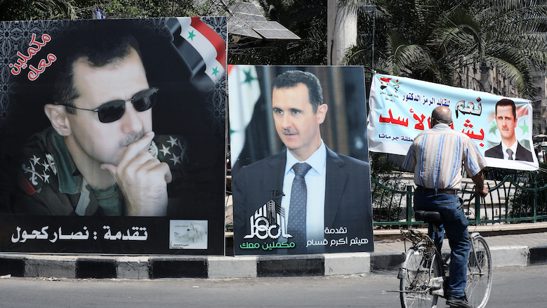 A man rides a bicycle past election campaign billboards depicting Syrian President Bashar al-Assad, a candidate for the upcoming presidential vote, in Damascus on May 23, 2021. (Photo: Louai Beshara/AFP)